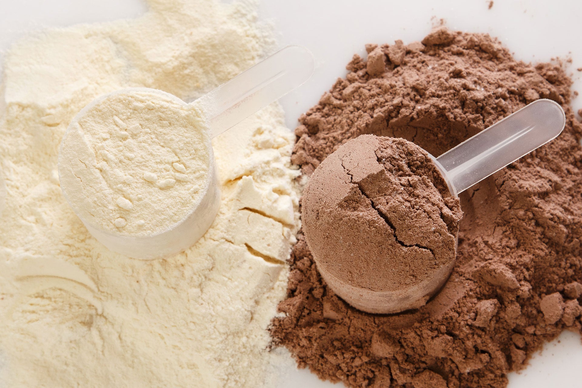 Scoops of vanilla and chocolate plant-based protein powder side by side