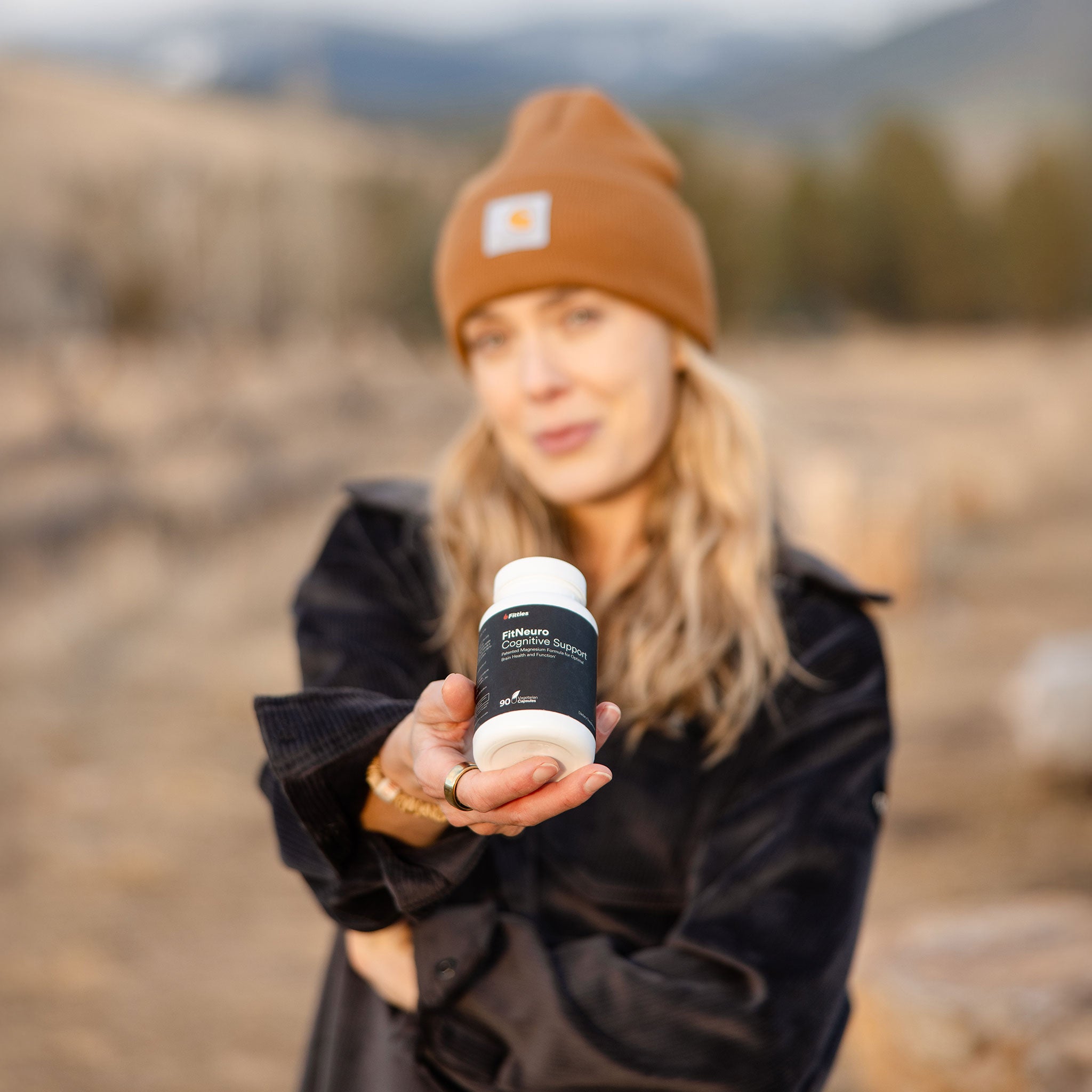 Athlete outdoors with bottle of Fitties FitNeuro