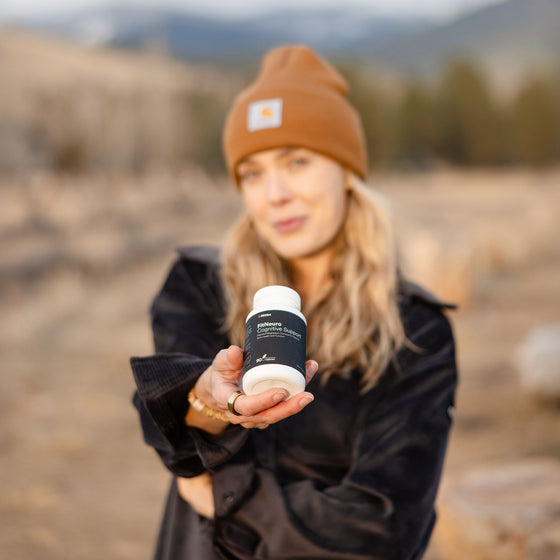 Athlete outdoors with bottle of Fitties FitNeuro