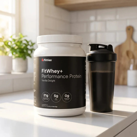 FitWhey+ Vanilla Delight grass-fed whey protein tub and shaker bottle on a bright kitchen counter