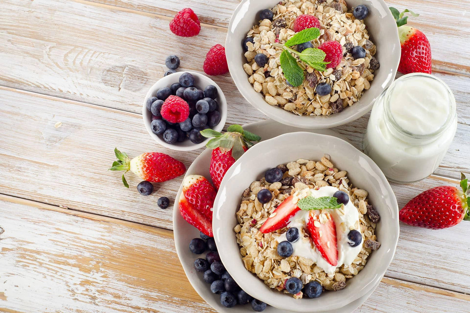 Bowls of muesli with fresh berries and yogurt