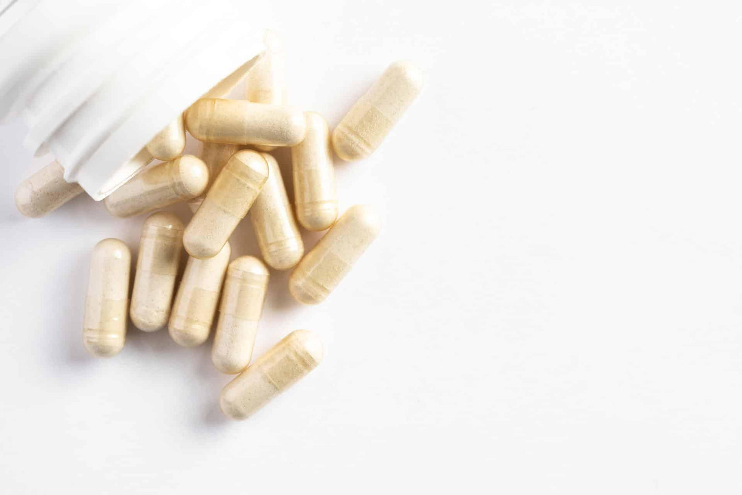 Top view closeup of probiotic capsules and bottle on white background