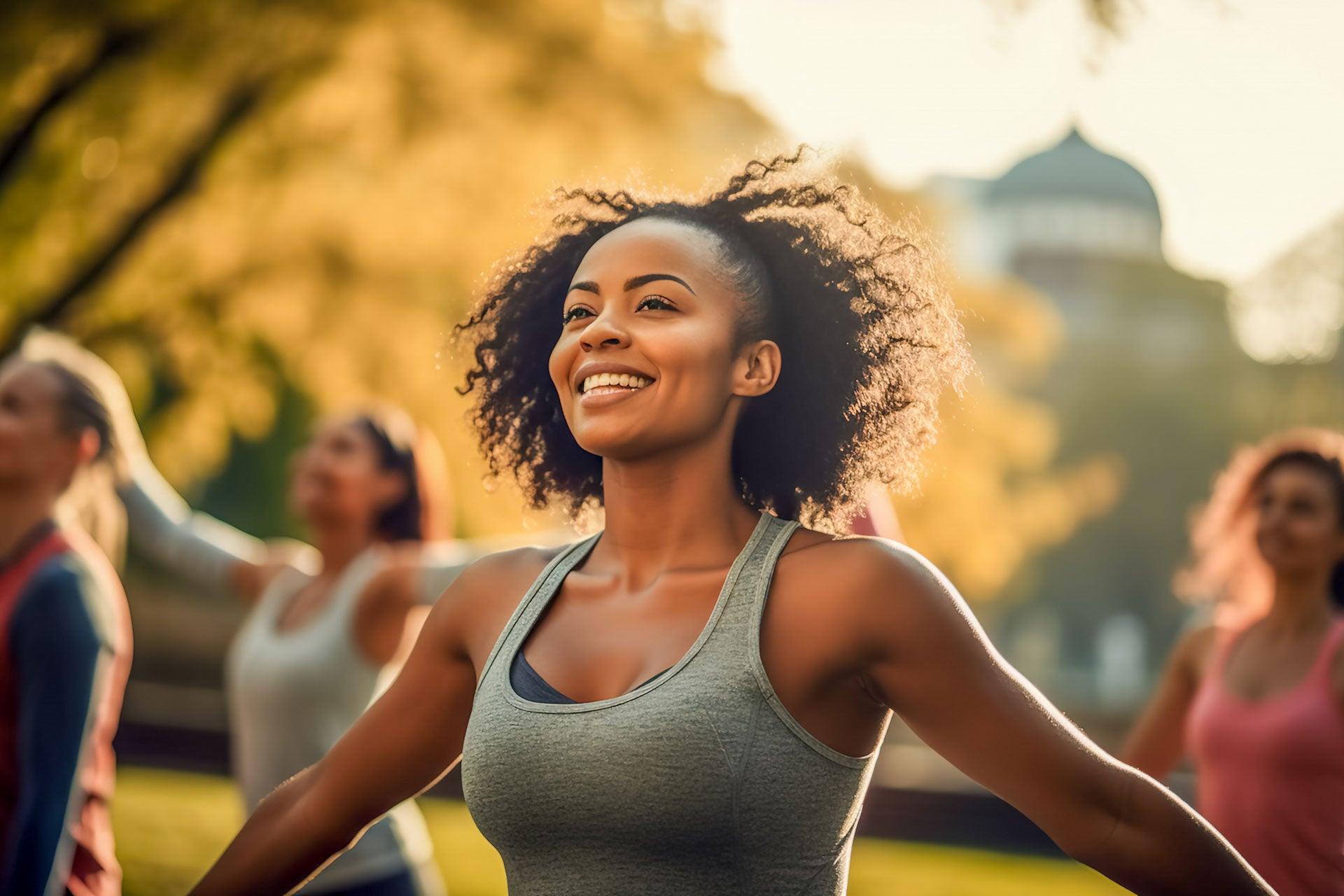 Fit female participating in motivational group workout in park