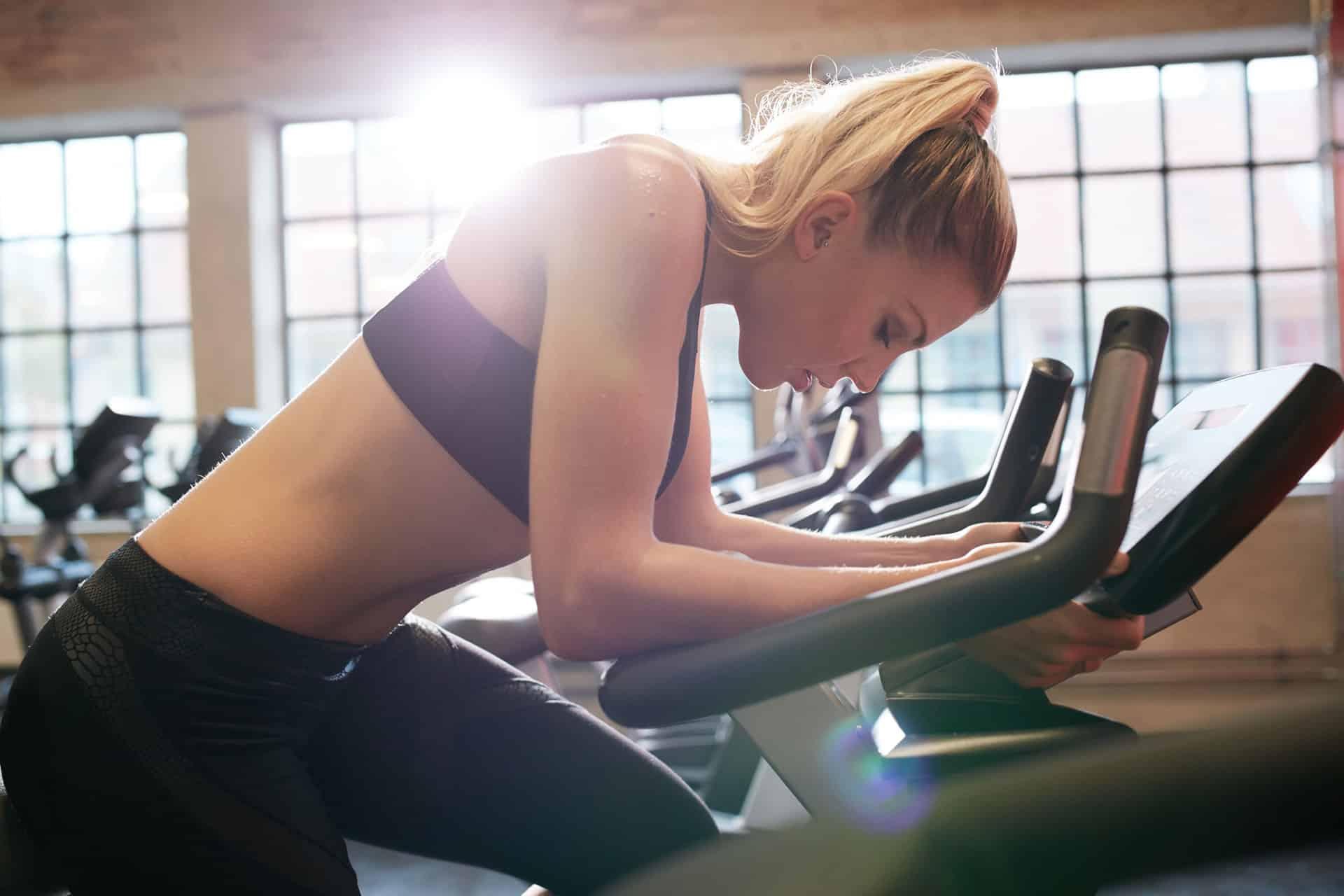 Female performing HIIT on stationary bike