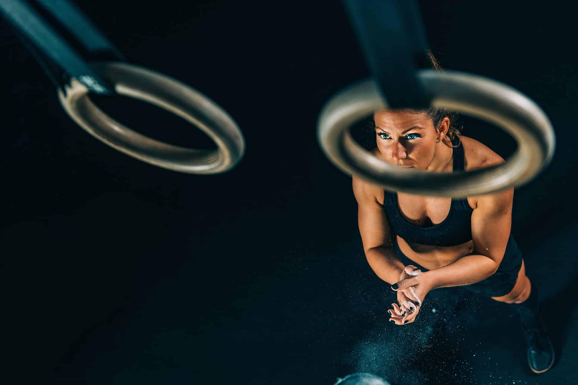 Female getting mentally focused to perform on gymnastics rings