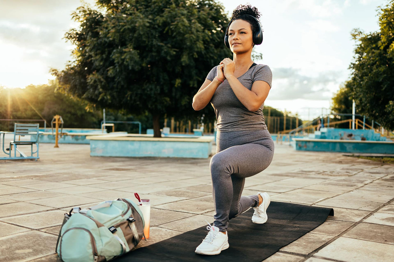 Female athlete exercising outdoors in a park at sunrise