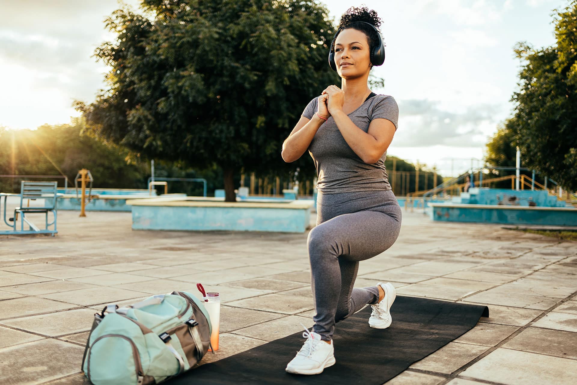 Female athlete exercising outdoors in a park at sunrise