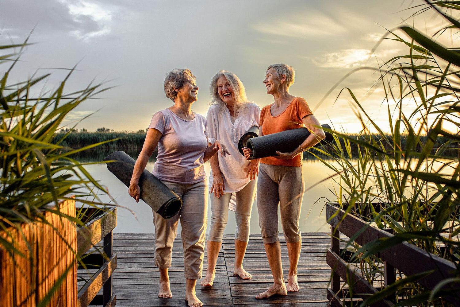 Three senior females talking on dock post-yoga