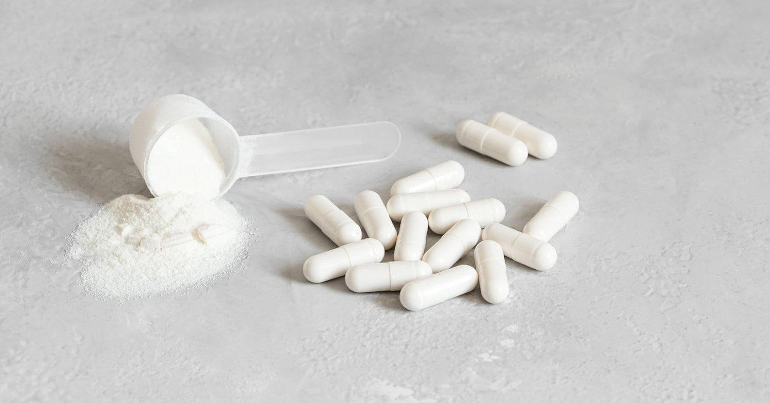 Closeup of Beta Hydroxy Beta Methylbutyrate (HMB) powder and tablet supplements