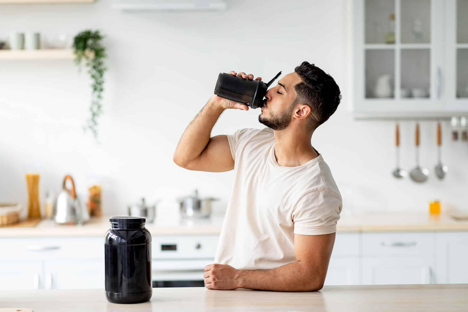 Male drinking meal replacement shake from shaker bottle