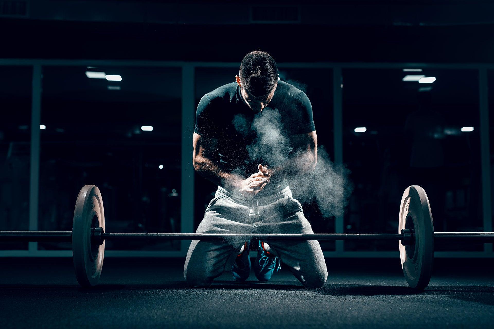 Fit male in gym preparing for barbell lift