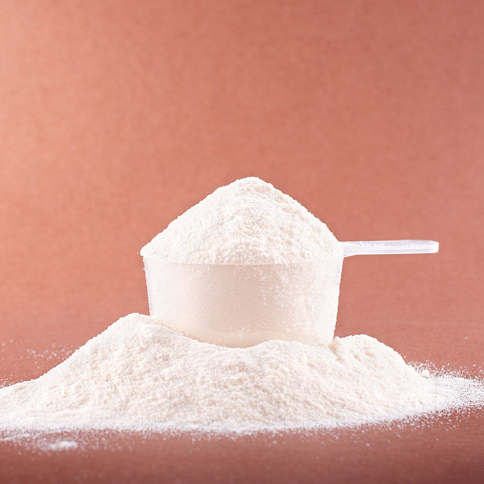 Closeup of a scoop of pre-workout powder on a plain background