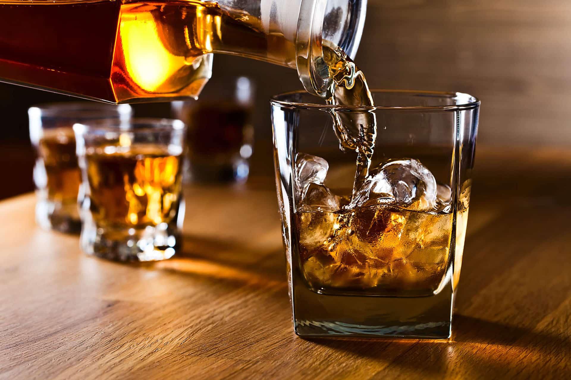 Closeup of whiskey being poured into rocks glass