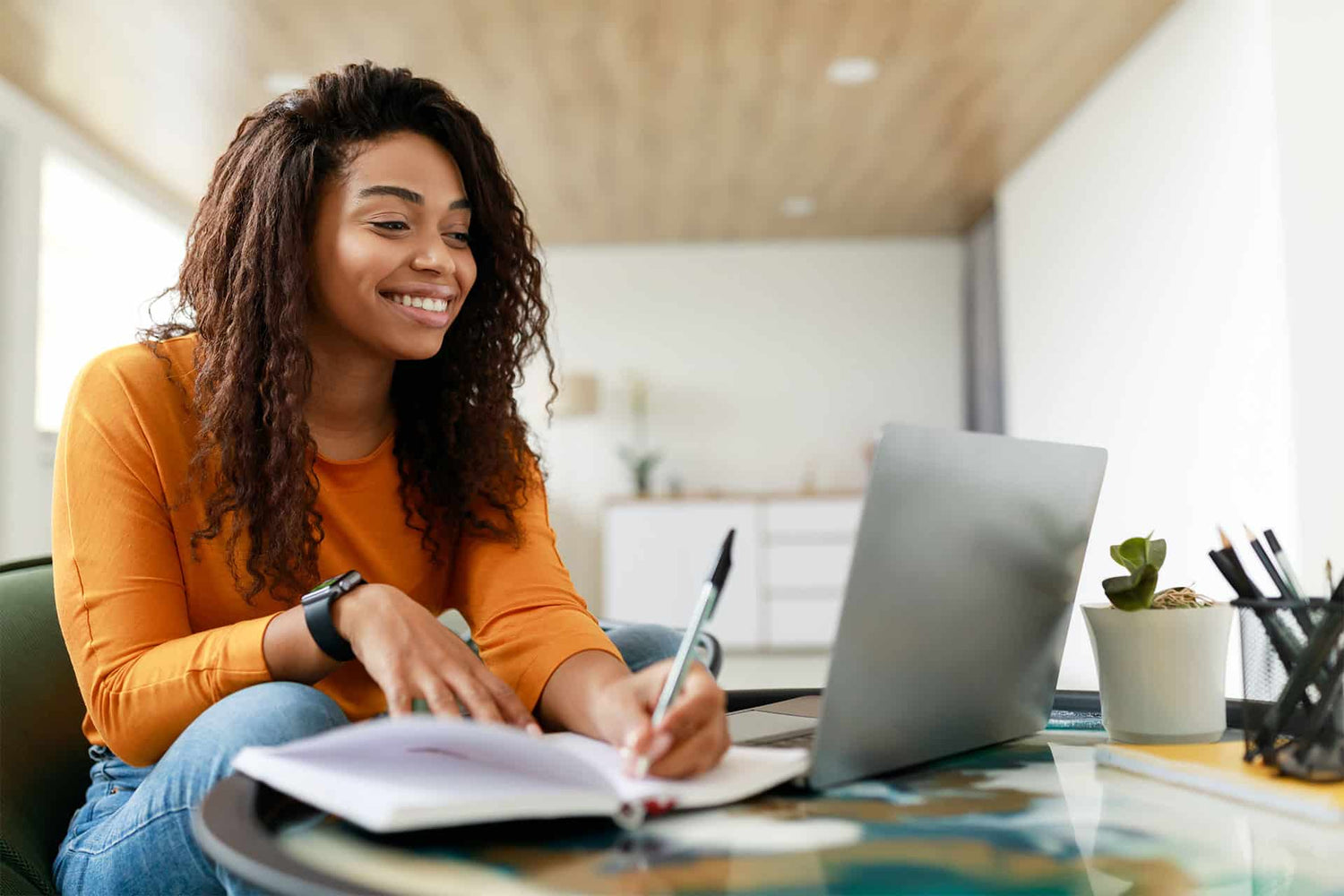 Smiling female studying on laptop computer