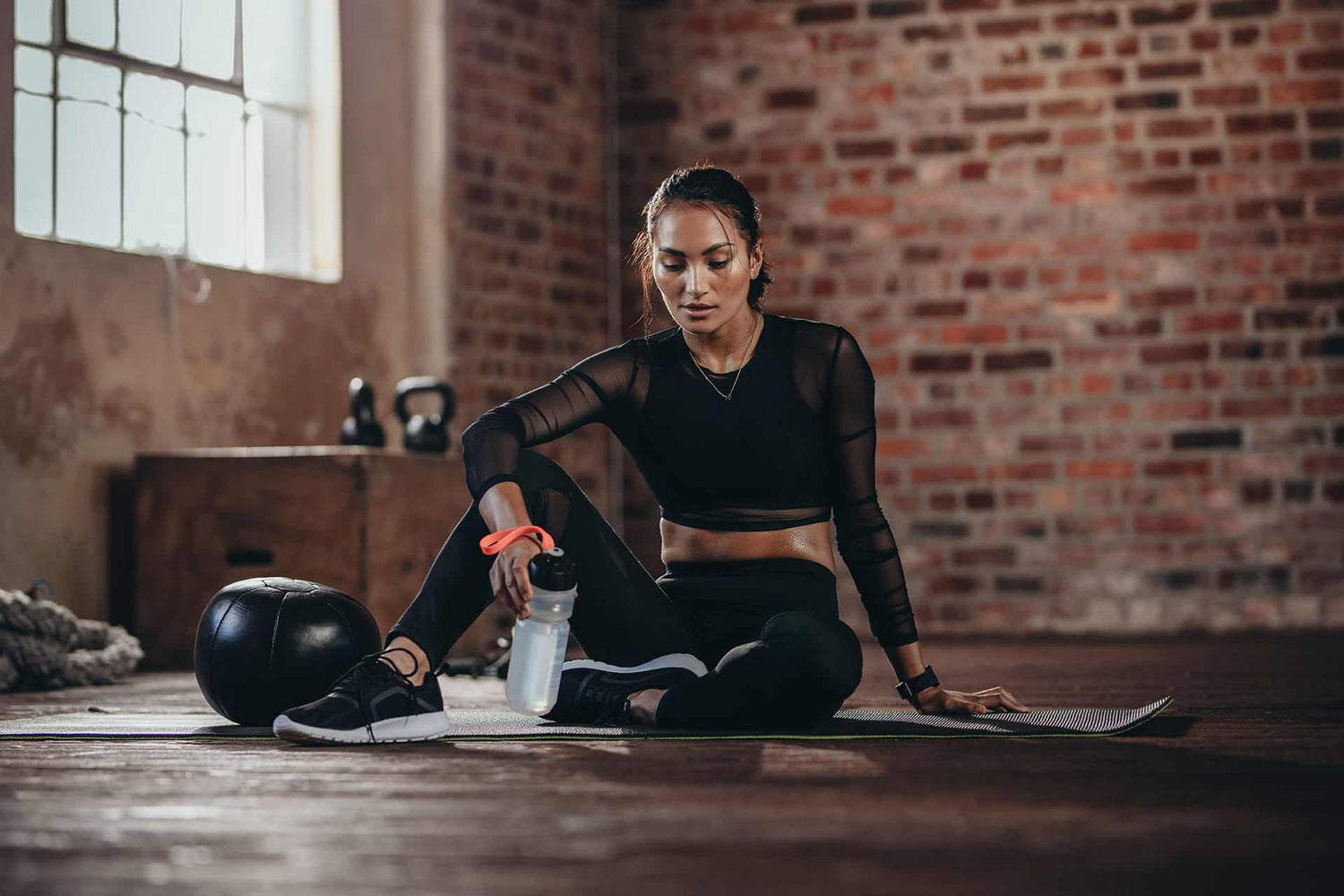 Fit female resting on yoga mat post-workout