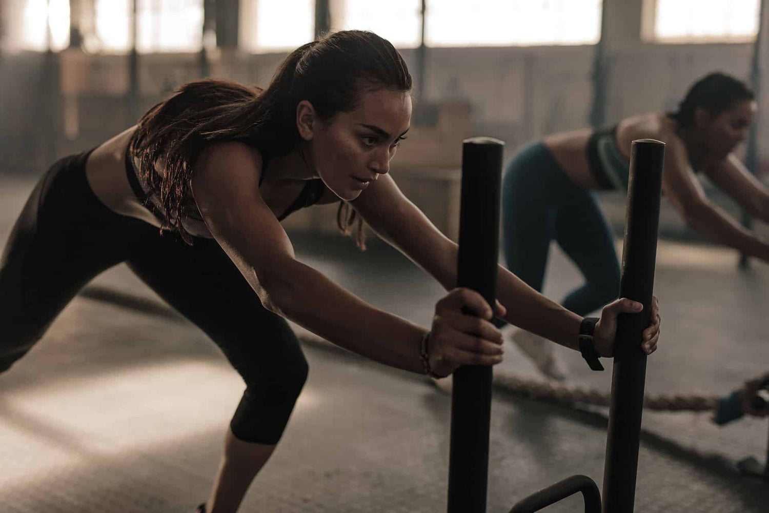 Females working out with weighted sleds