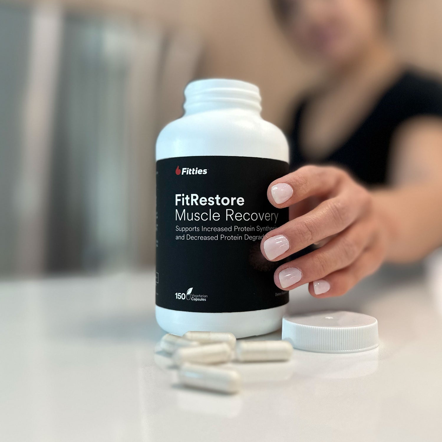 Closeup of FitRestore bottle and capsules on kitchen counter