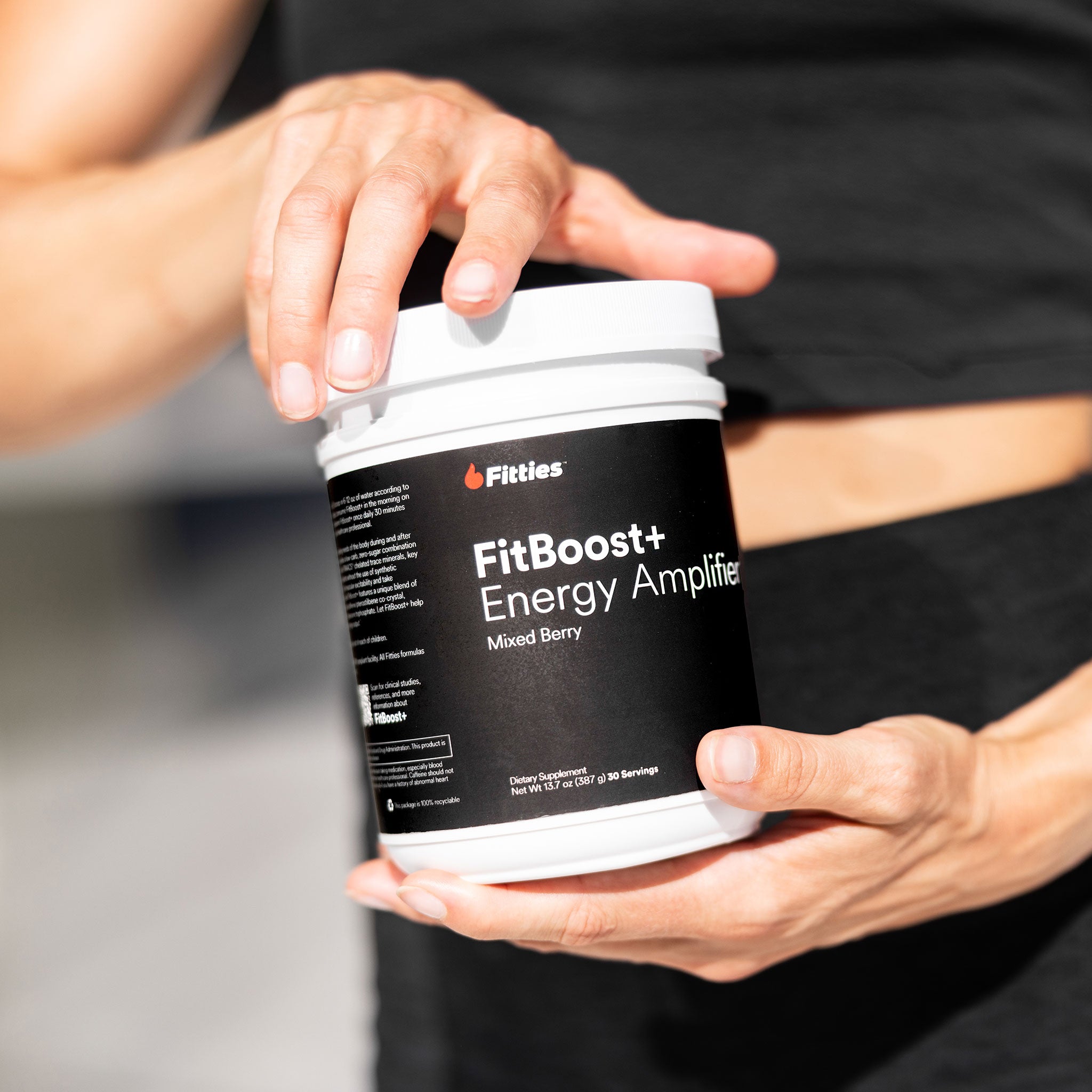 Closeup of female athlete holding bottle of Fitties FitBoost+