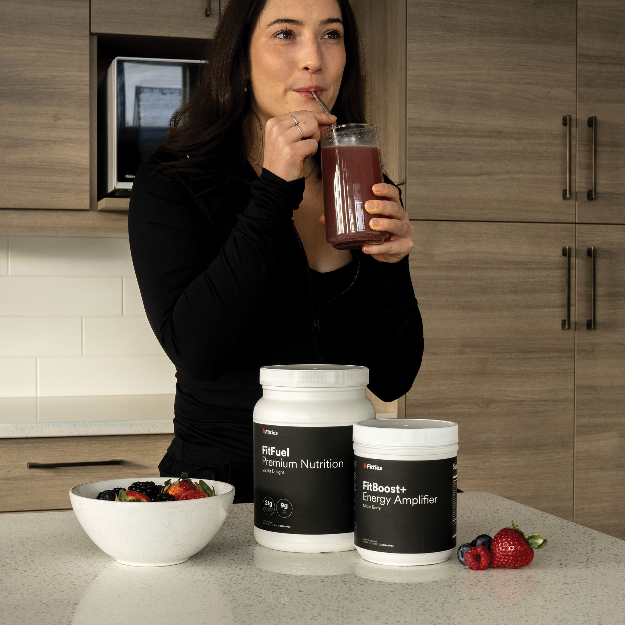 Fitness model enjoying smoothie made from Fitties FitFuel and FitBoost+