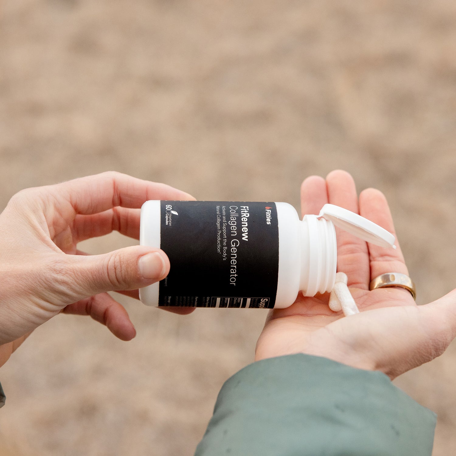 Closeup of Fitties FitRenew bottle and capsules in hands