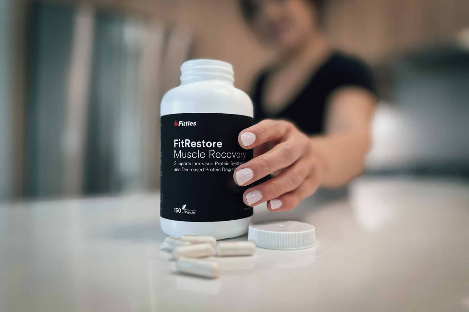 Closeup of FitRestore bottle and capsules on kitchen counter