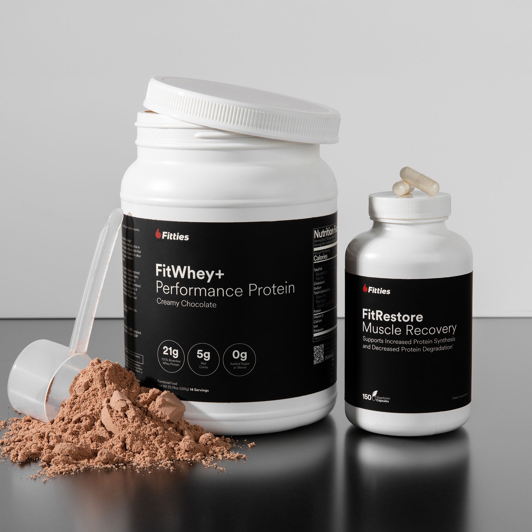 FitWhey+ Performance Protein container with chocolate powder and FitRestore Muscle Recovery bottle on a gray background